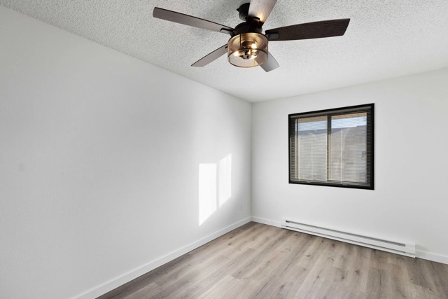 Living room with new flooring and ceiling fan at The Cypress